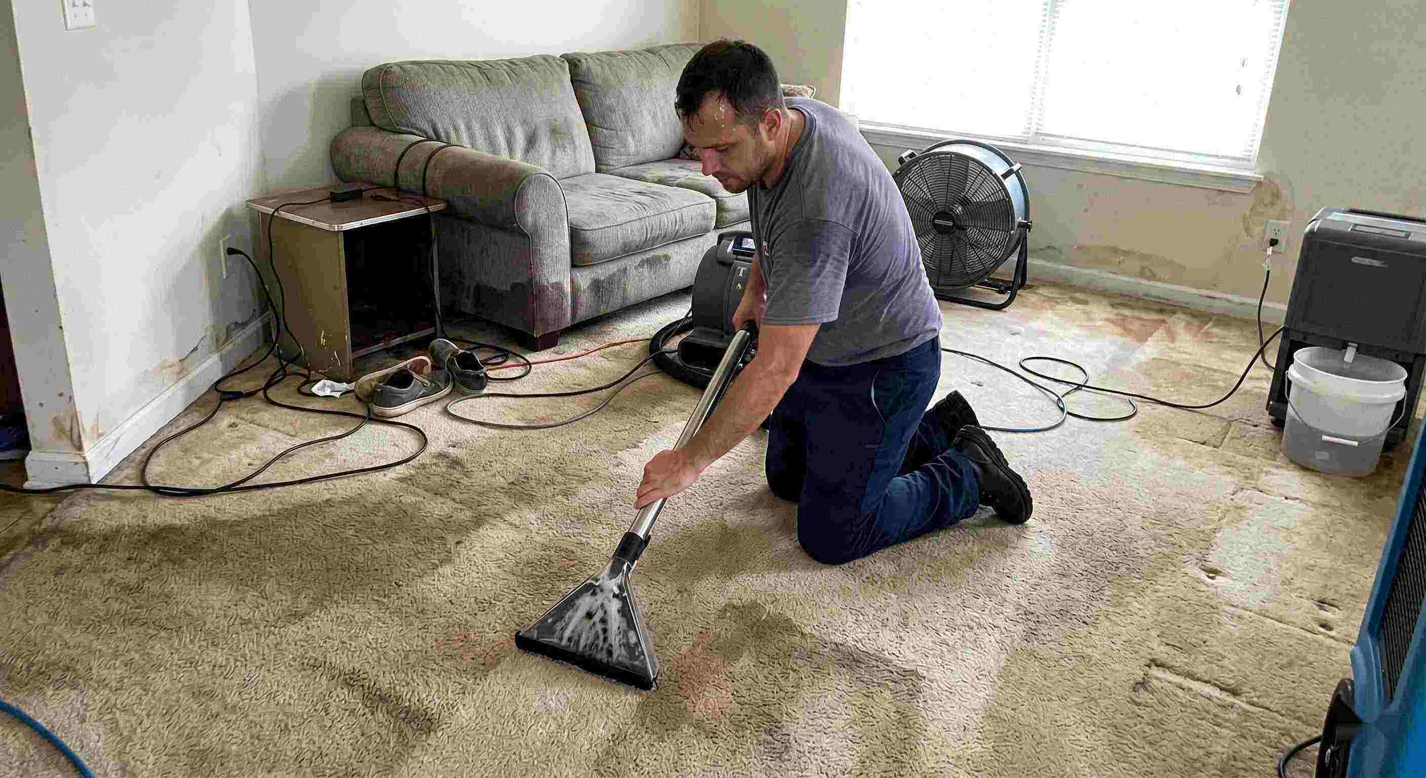 Best technician performing carpet water extraction in a residential home using professional equipment after water damage in Maricopa