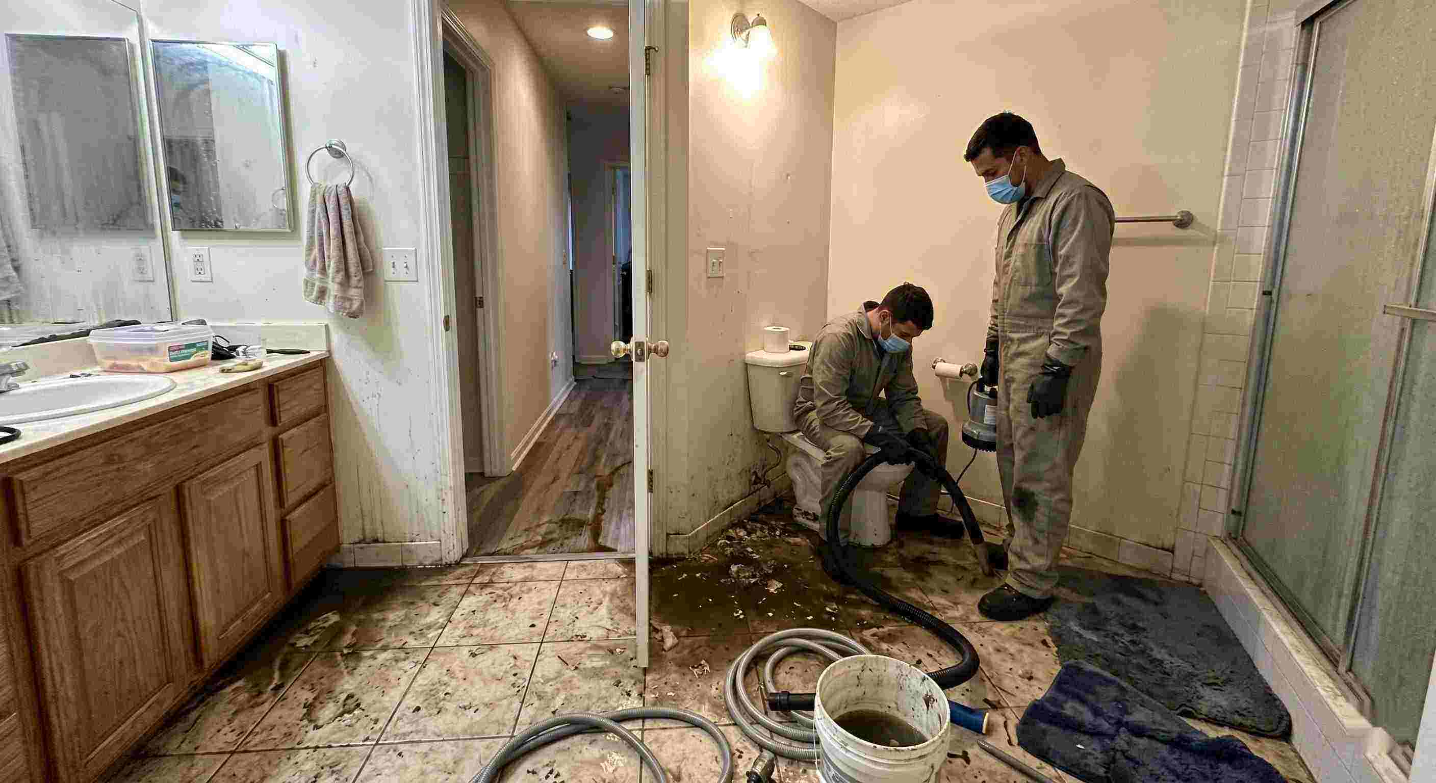 Reliable septic tank backup cleanup in Maricopa bathroom with technicians removing contaminated water and sanitizing affected areas