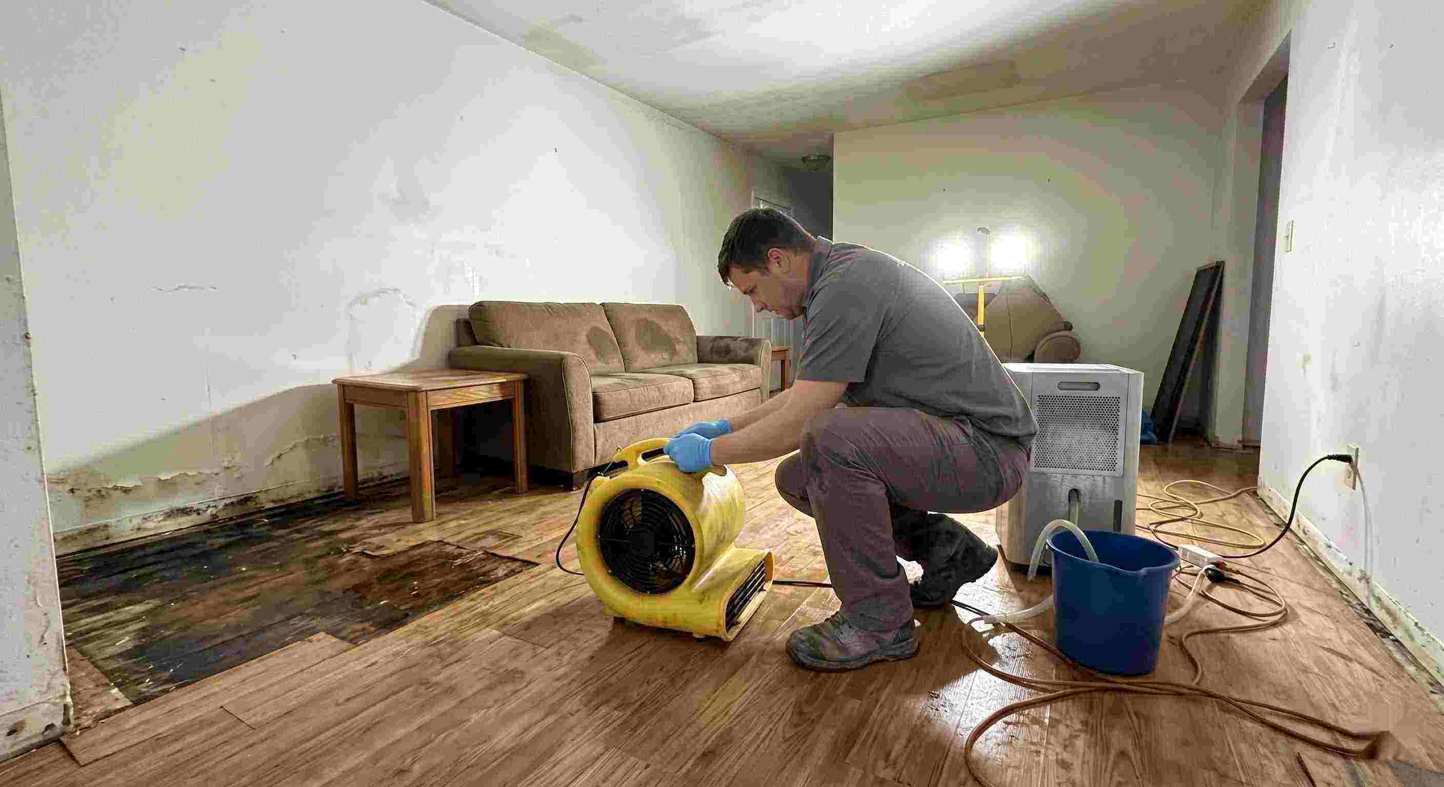Local water damage restoration technician drying wet floors with equipment during cleanup process in Prescott Valley